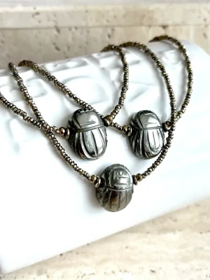 collier ras de cou en hématites et scarabée sculptée en pyrite